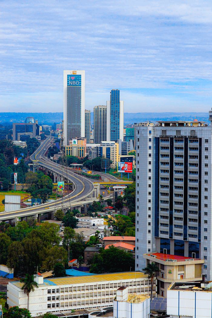 Aerial view of Nairobi's modern skyline featuring winding highways and iconic skyscrapers.